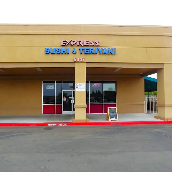 Exterior of Express Sushi & Teriyaki, a tan building with blue and pink signage and an "OPEN" sign.