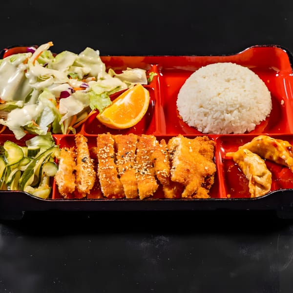 Express Sushi & Teriyaki bento box with fried chicken, rice, salad, cucumber salad, orange slice, and dumplings.