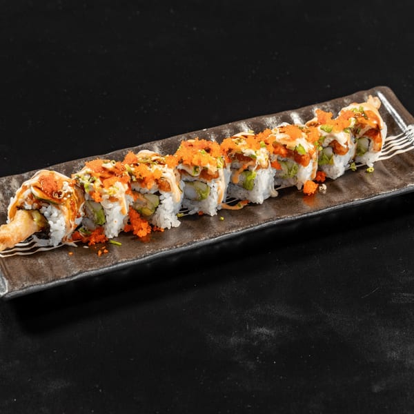 A plate of eight sushi rolls with white rice, orange roe, green onions, and creamy sauce.